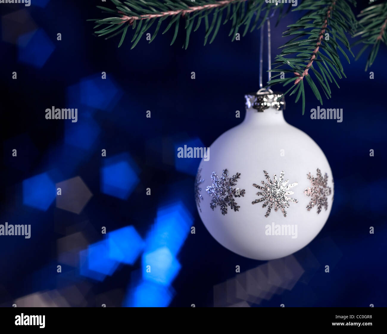 Christmas bauble hanging on fir branch in dark blurry back Stock Photo