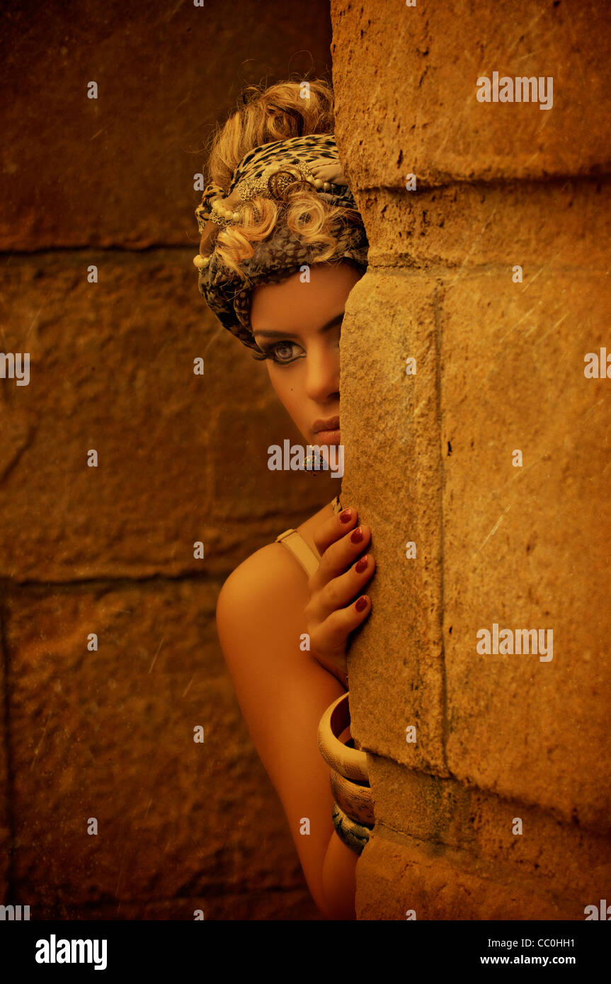 Young girl hiding behind wall Stock Photo