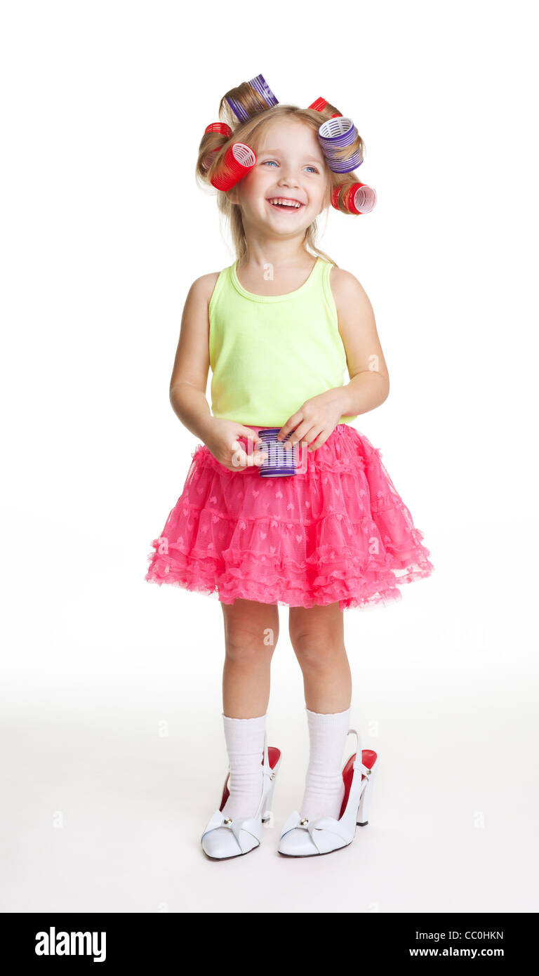 fashion-conscious little girl with mothers rollers and big size shoes Stock Photo