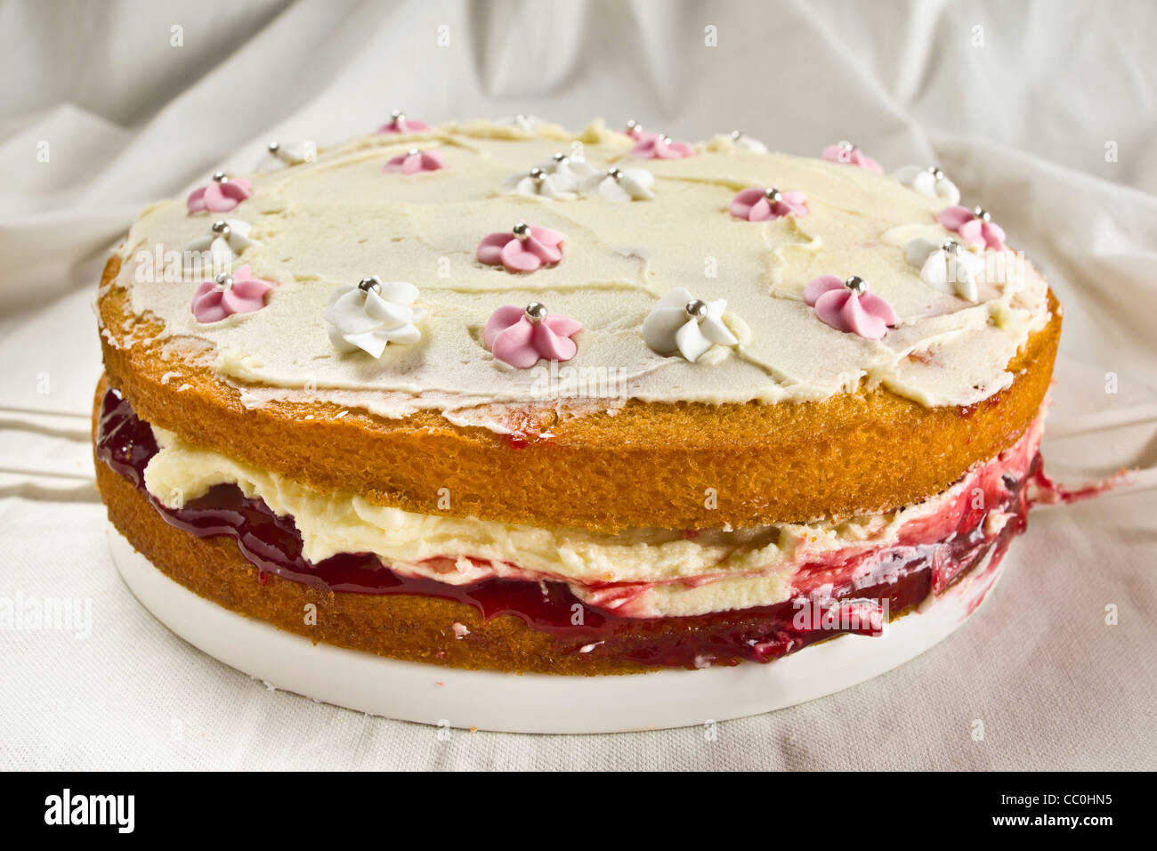 Home baked Victoria sponge cake with buttercream and raspberry jam