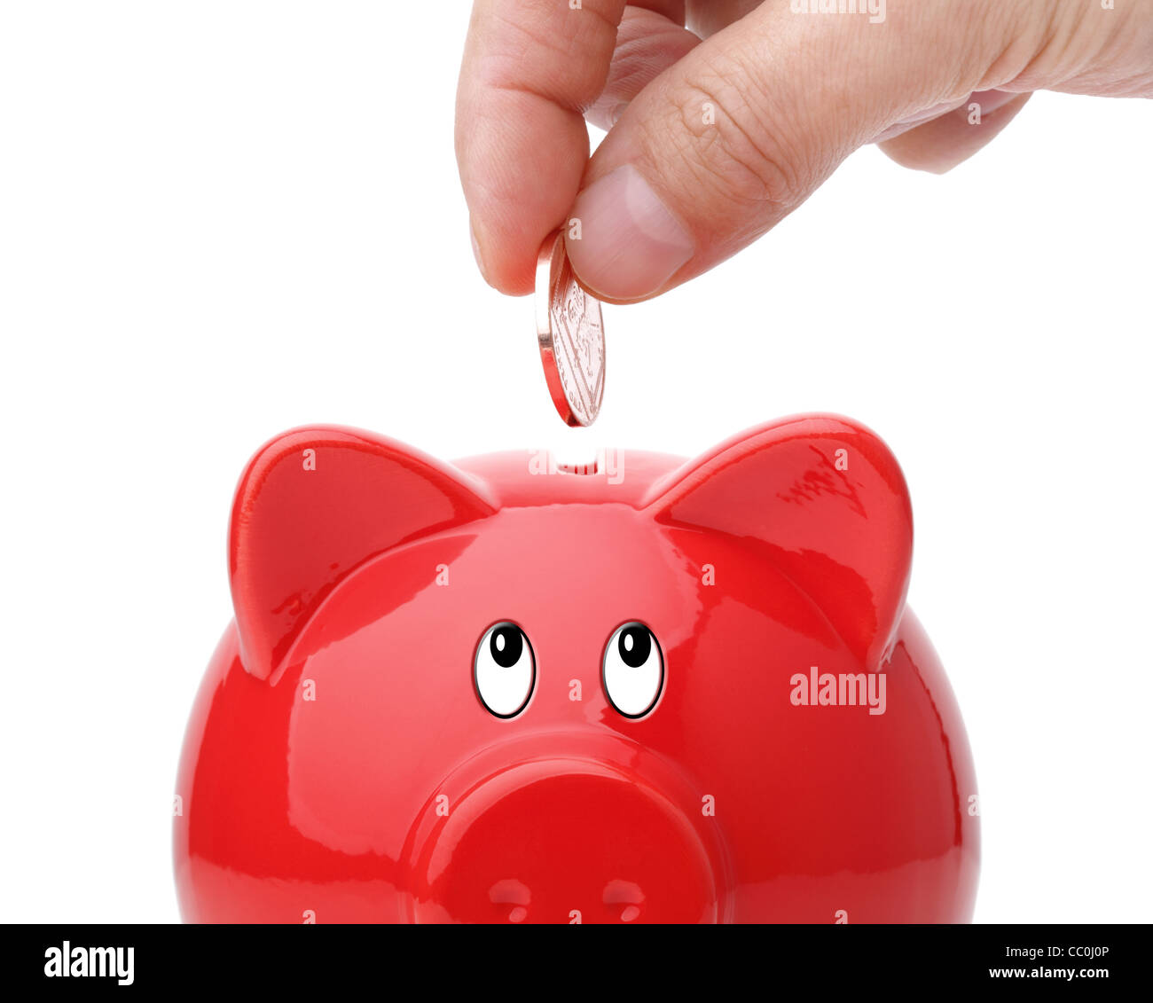 Inserting coin into a piggy bank Stock Photo