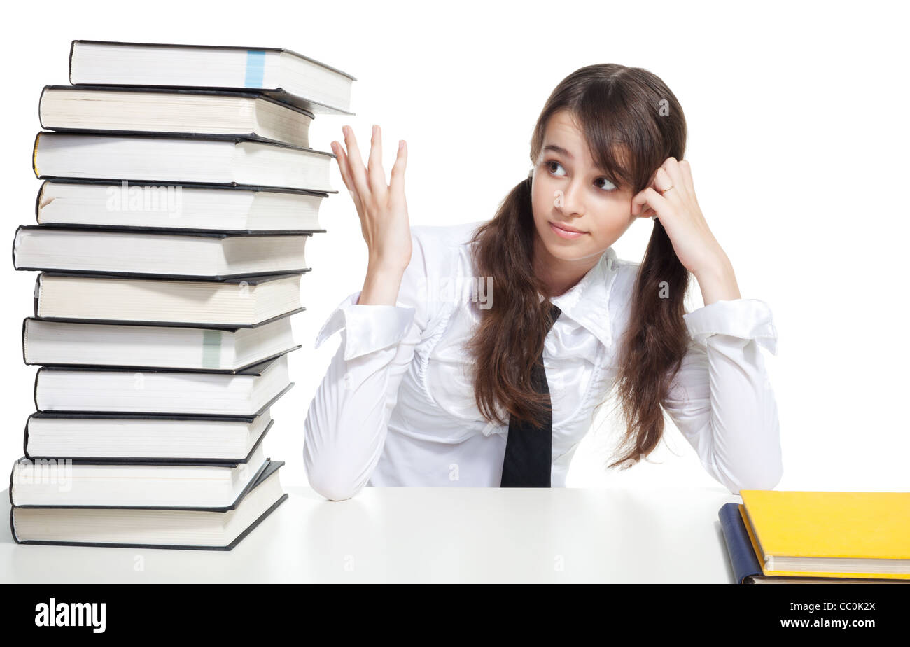 Sad school girl sitting with pile of books Stock Photo - Alamy