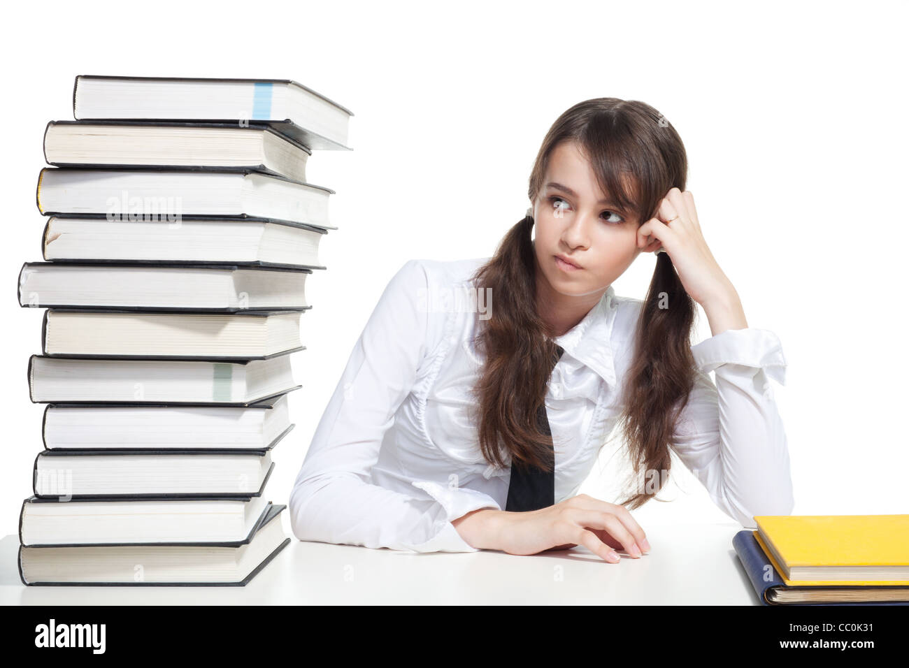 Girl sitting with pile of books and thinking Stock Photo - Alamy