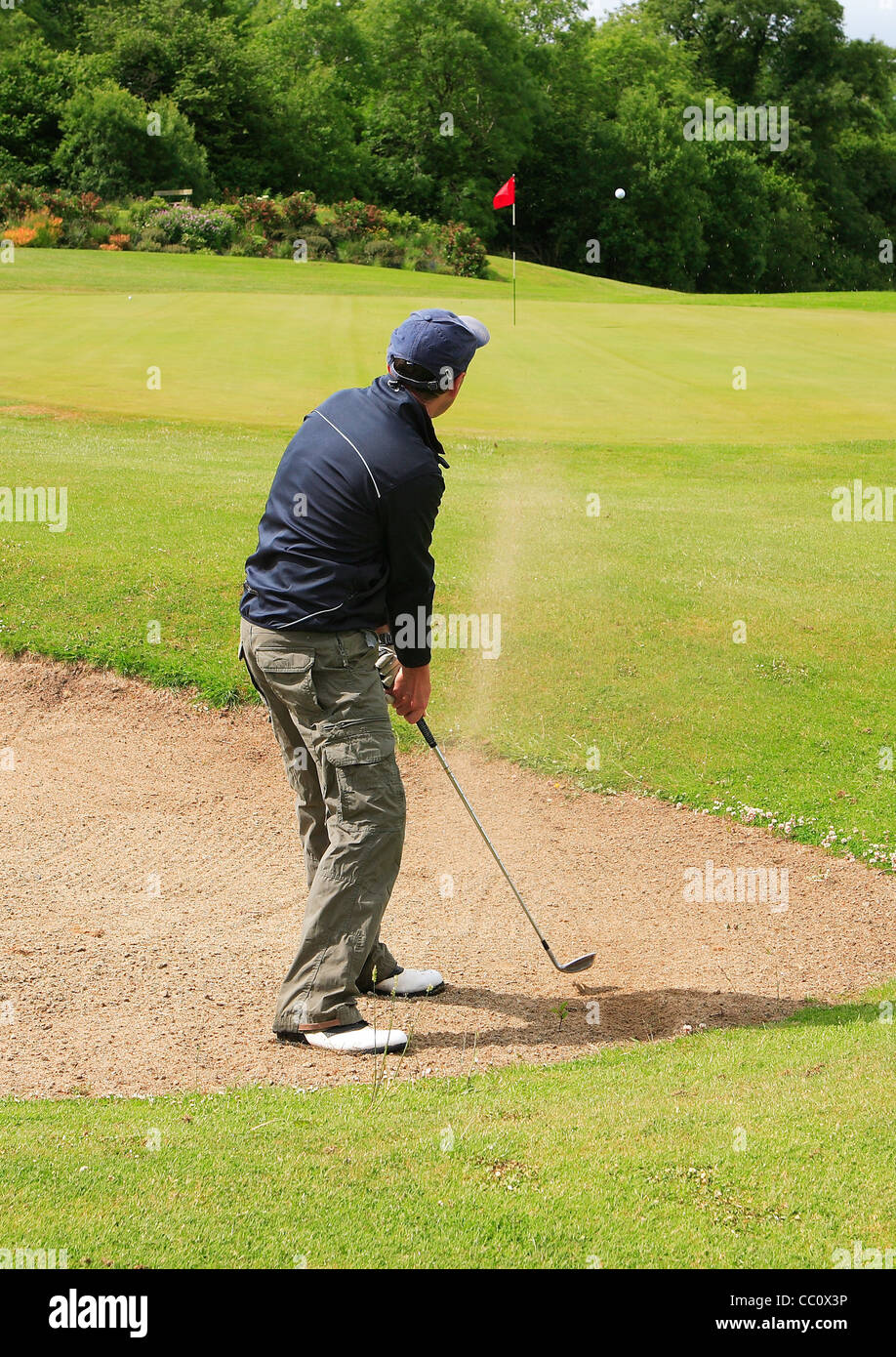 Golfer hitting ball out of bunker. Ireland Stock Photo
