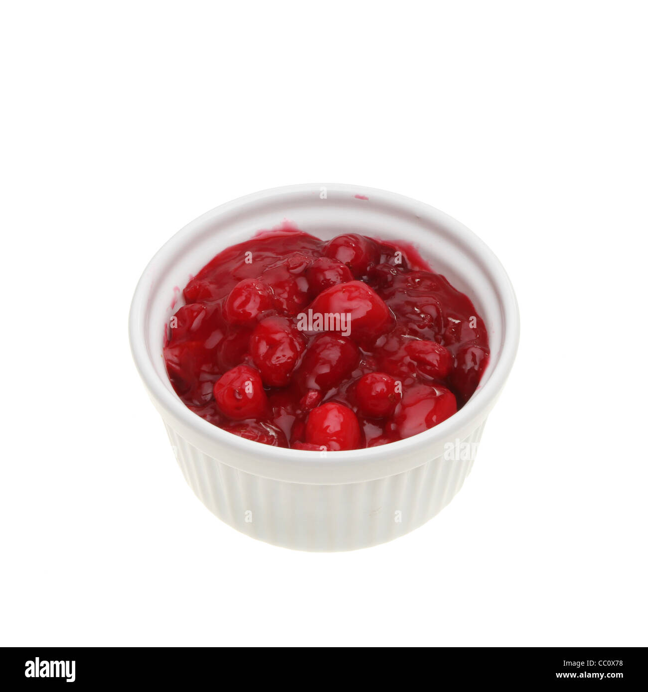 Fresh homemade cranberry sauce in a ramekin isolated against white Stock Photo