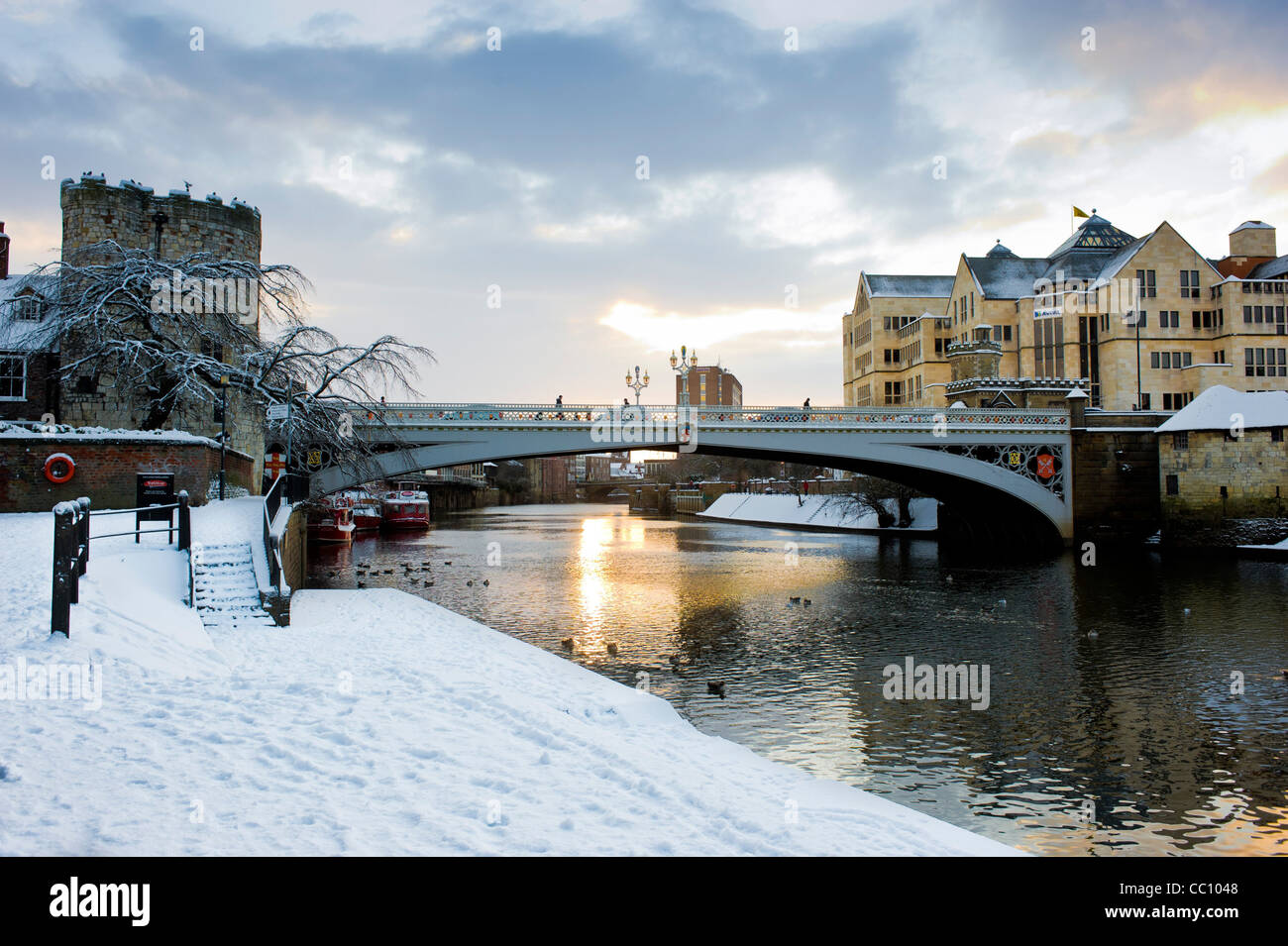 Snow covered riverbank and Lendal bridge over the river Ouse in York Stock Photo