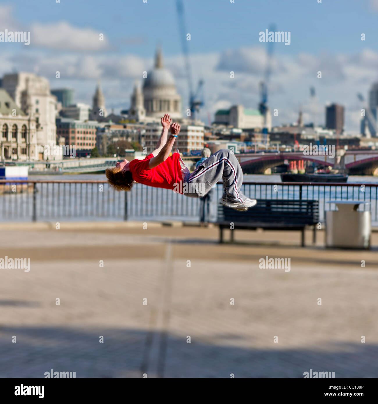 Teenager doing a back flip, River Thames, London-England Stock Photo