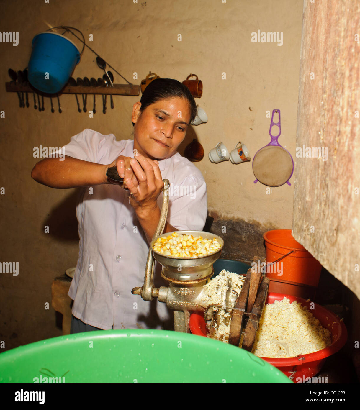 Campesino woman grinding corn for tortillas in Honduras Stock Photo