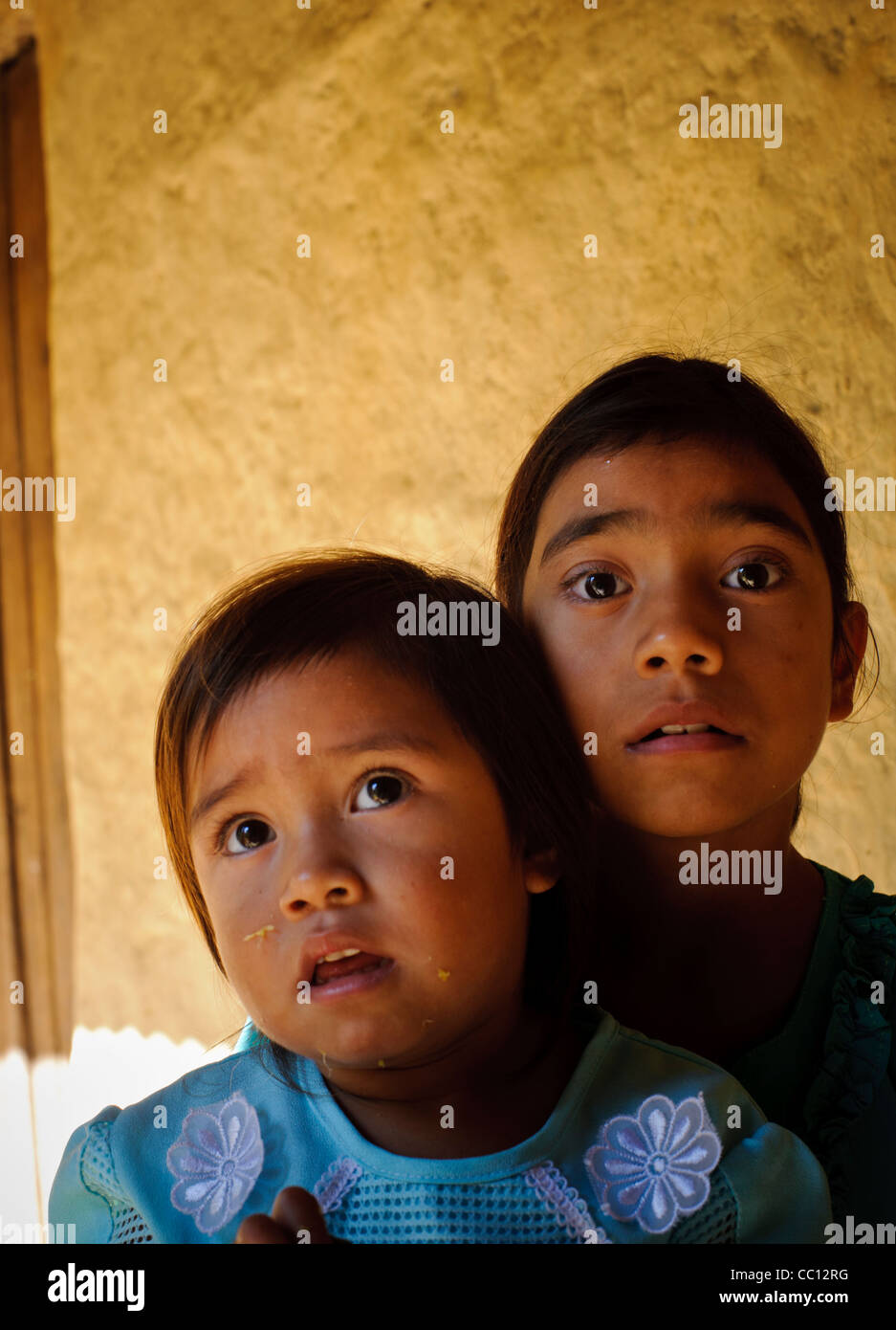 Two young girl children of a poor campesino in the mountains of Honduras. Older one carrying younger one Stock Photo