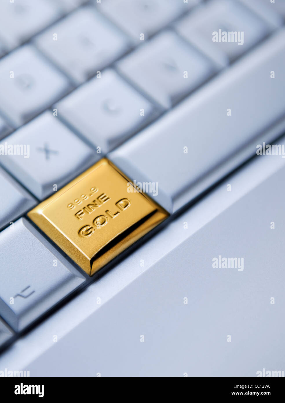 Buying Gold Onllne concept. Detail of a keyboard with one key as a solid gold bar Stock Photo