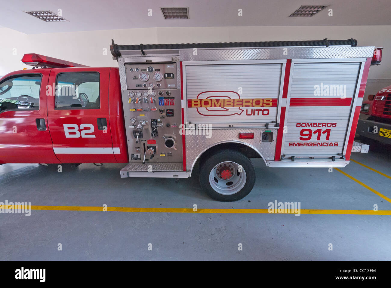 Side view of a red fire truck parked in a fire station in Quito