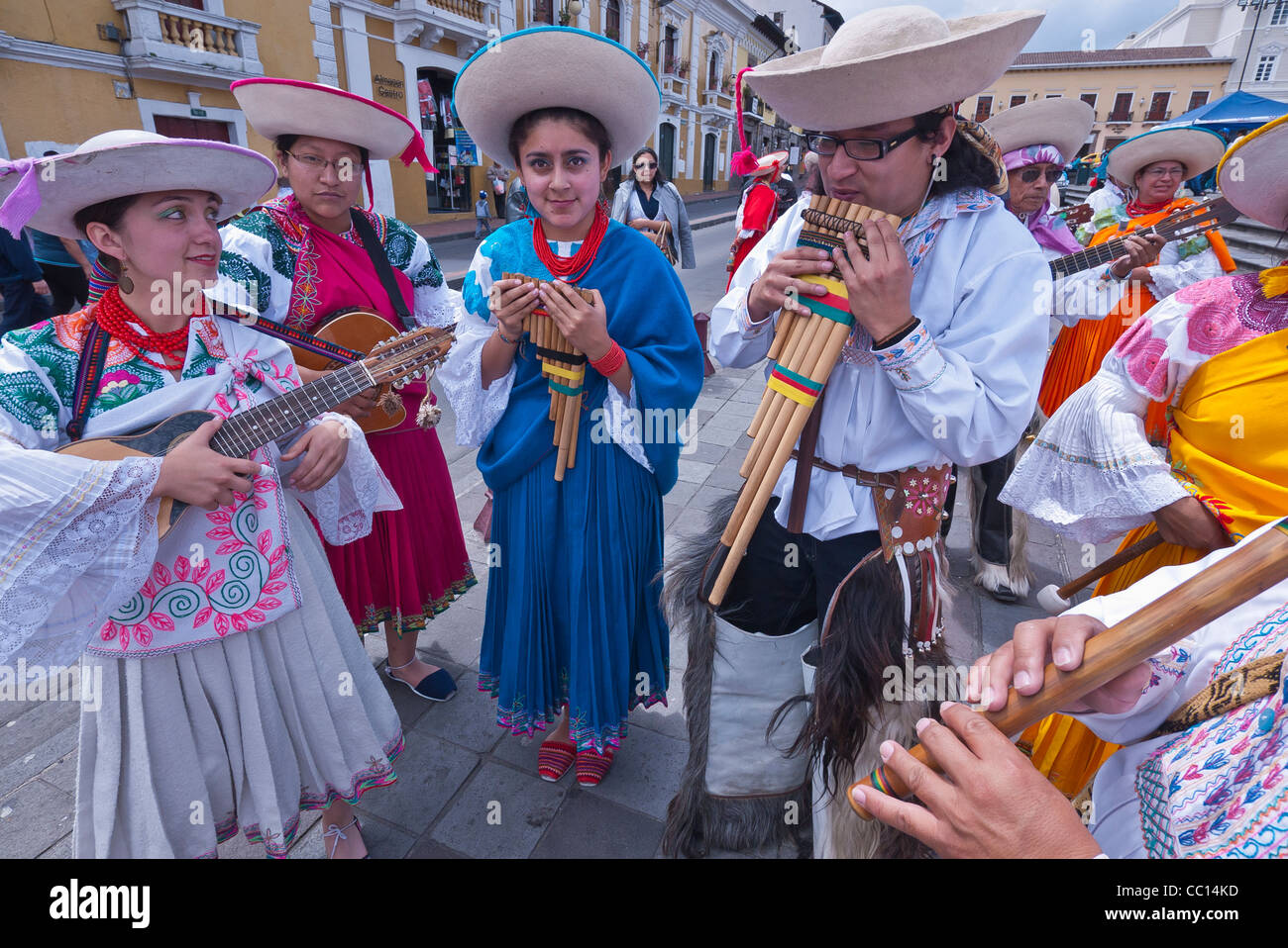 Hispanic men and women musicians play their musical instruments in a plaza in Quito, Ecuador