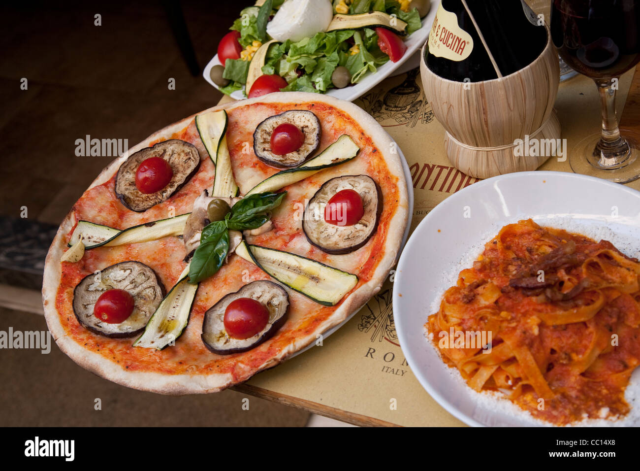 Pizza and Pasta with Wine on Table in Restaurant in Rome Stock Photo