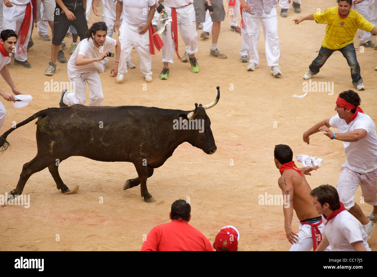 People being chased in the bull ring at the festival of San Fermin in Pamplona, Spain. Stock Photo