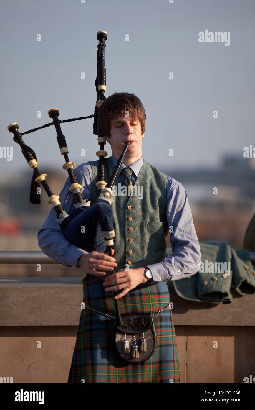 Young man playing the bagpipes Edinburgh Princes Street. Stock Photo