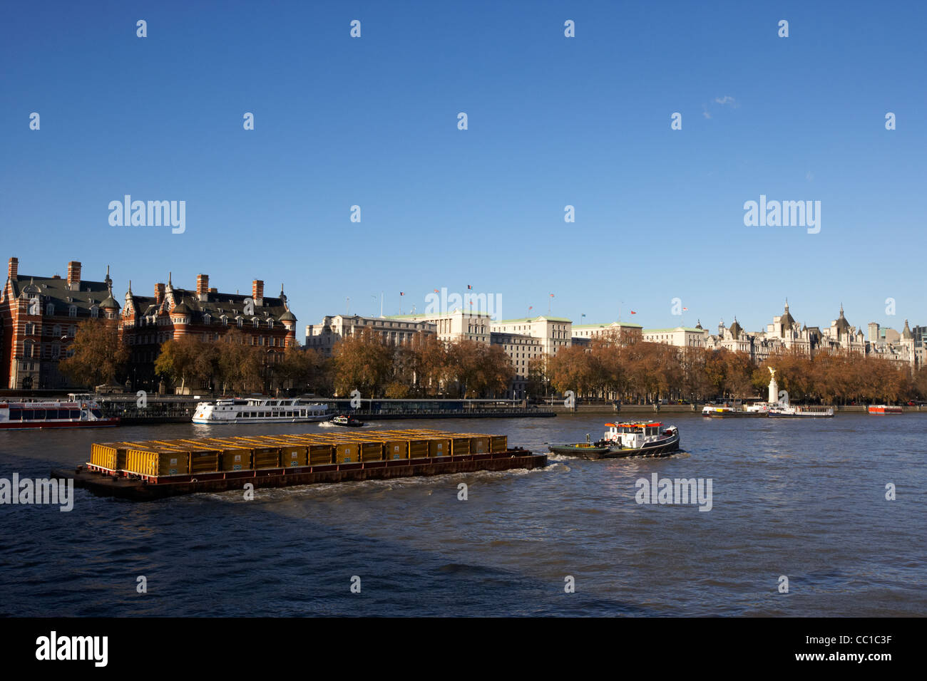 tug towing cory waste in sealed containers on barge in the river thames London England UK United kingdom Stock Photo