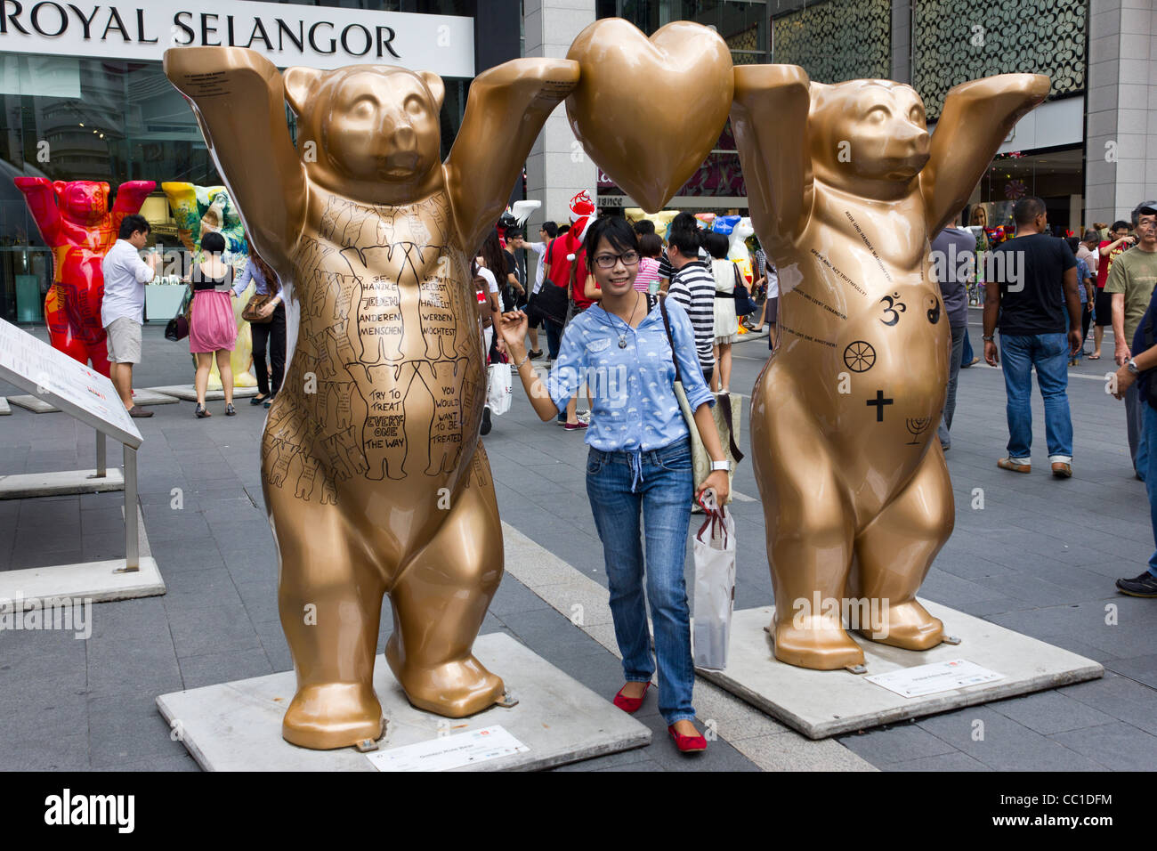 girl posing for photograph, United Buddy Bears exhibition, Pavilion Mall, Kuala Lumpur, Malaysia Stock Photo