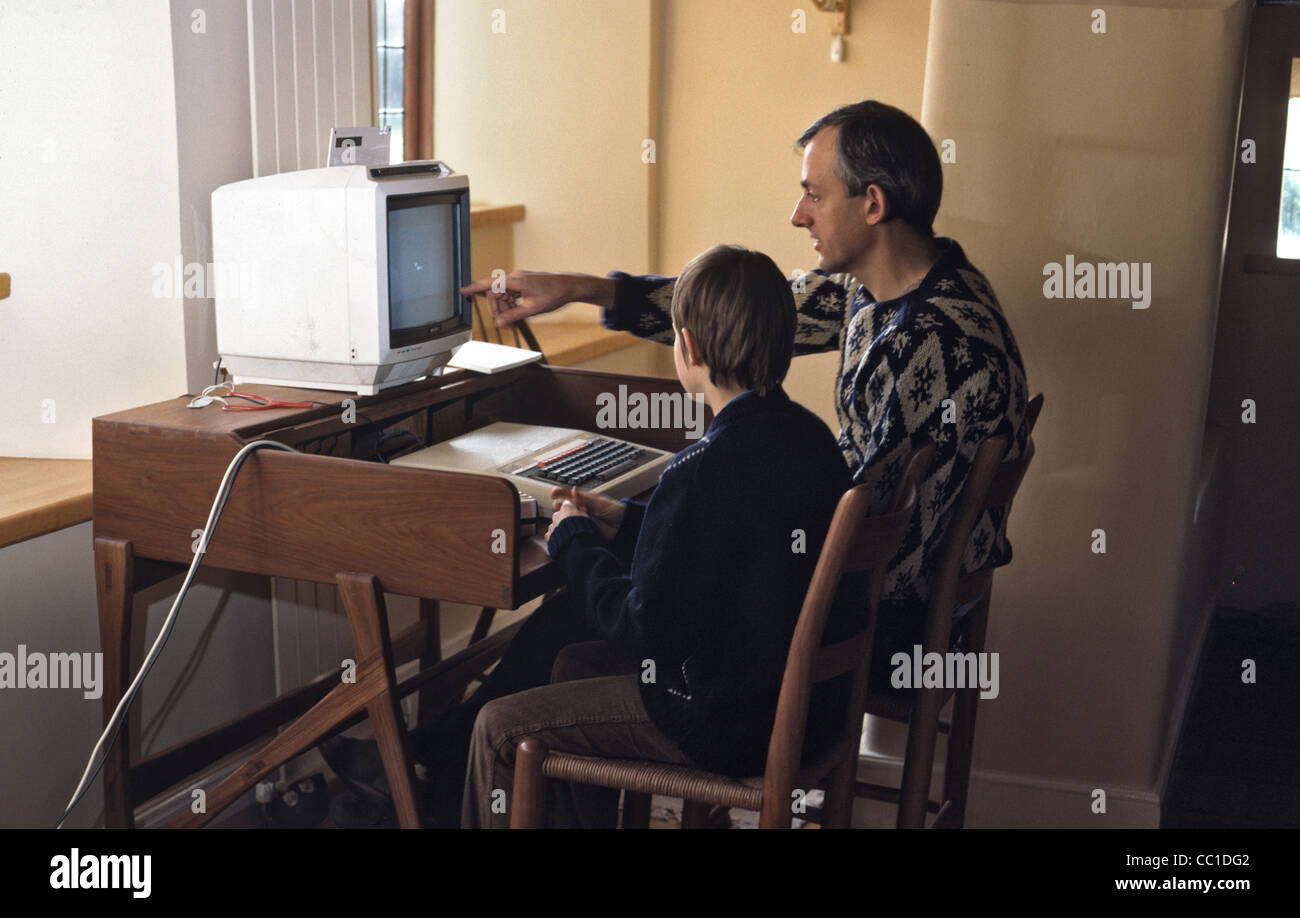 father and son playing on one of the first home computer called Archimedes Acorn Stock Photo