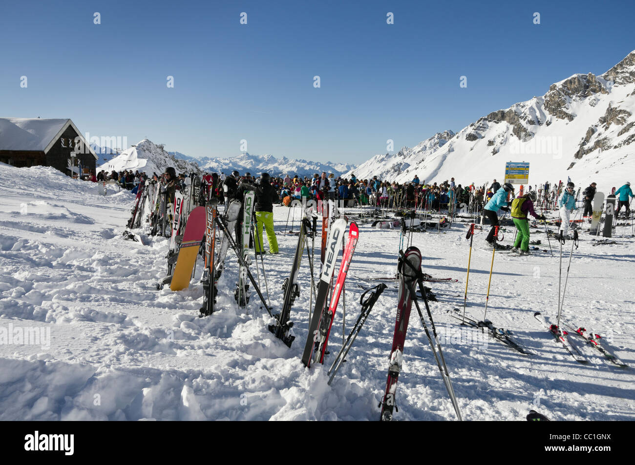 Skis in snow outside Ulmer Hutte ski restaurant busy with skiers in Austrian Alps in winter St Anton am Arlberg Tyrol Austria Stock Photo