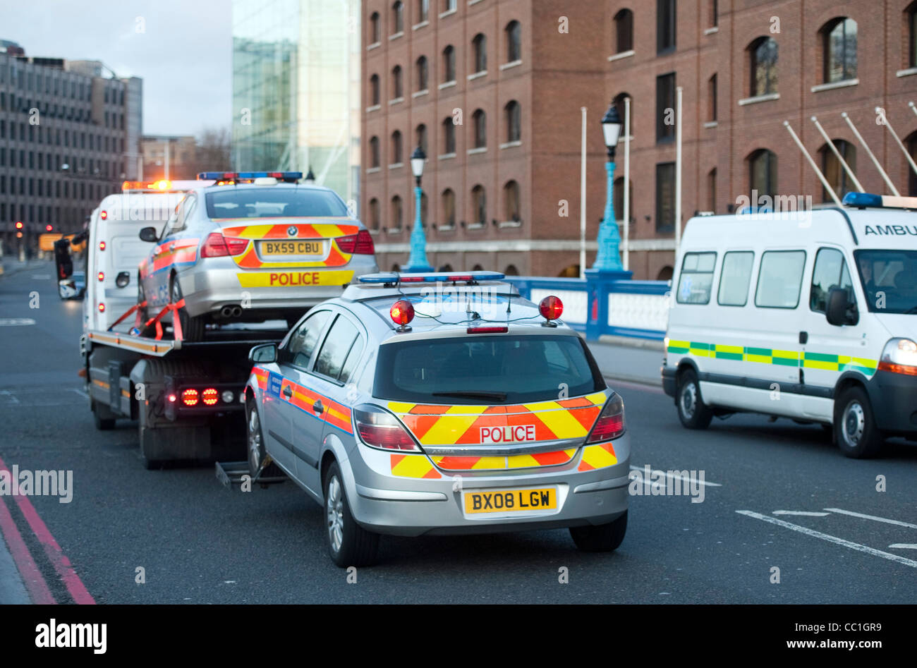 Police cars being towed by breakdown lorry Stock Photo