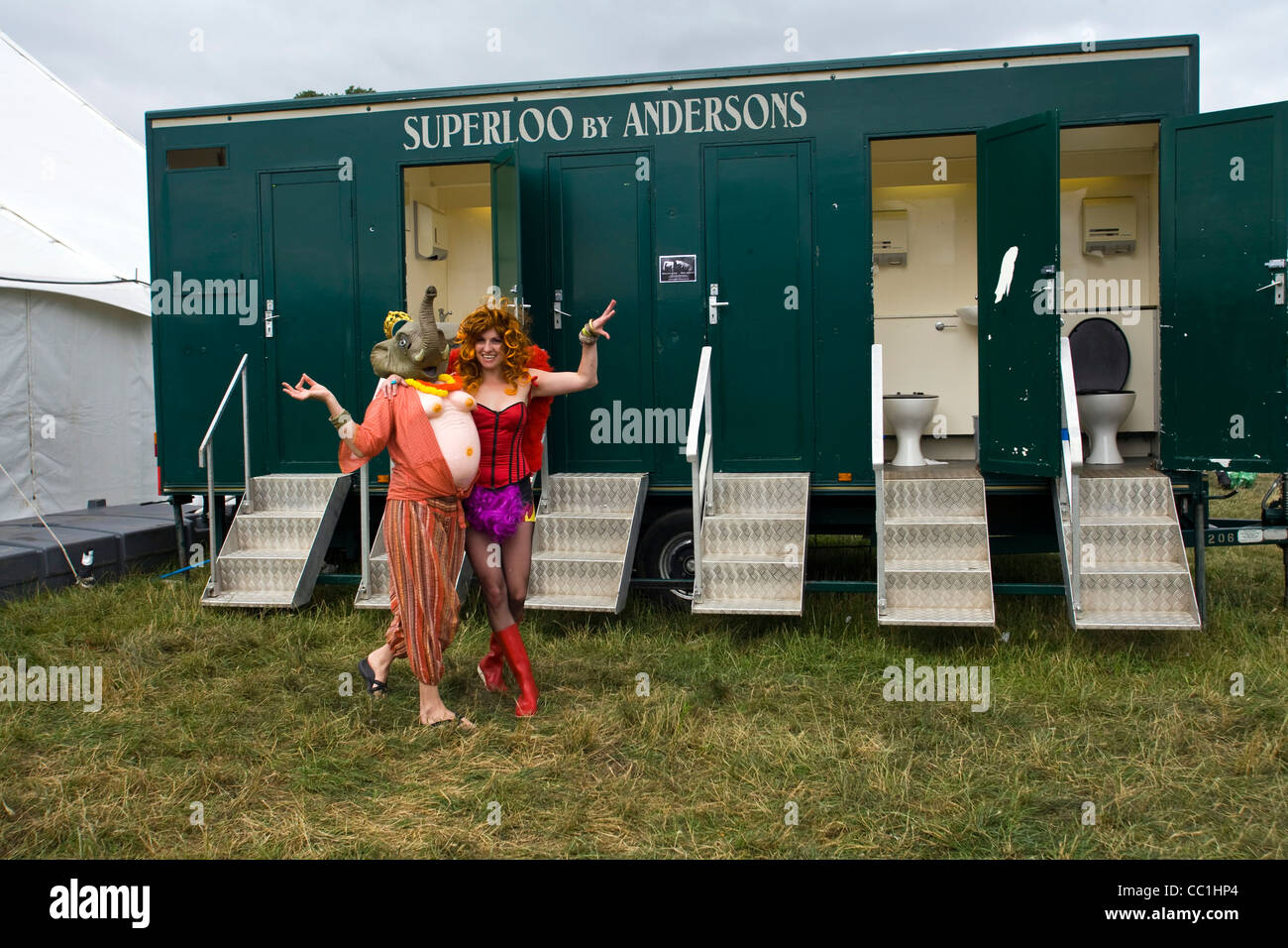 A couple in fancy dress walk past the public toilets at the Standon Calling Festival in Hertfordshire, UK Stock Photo