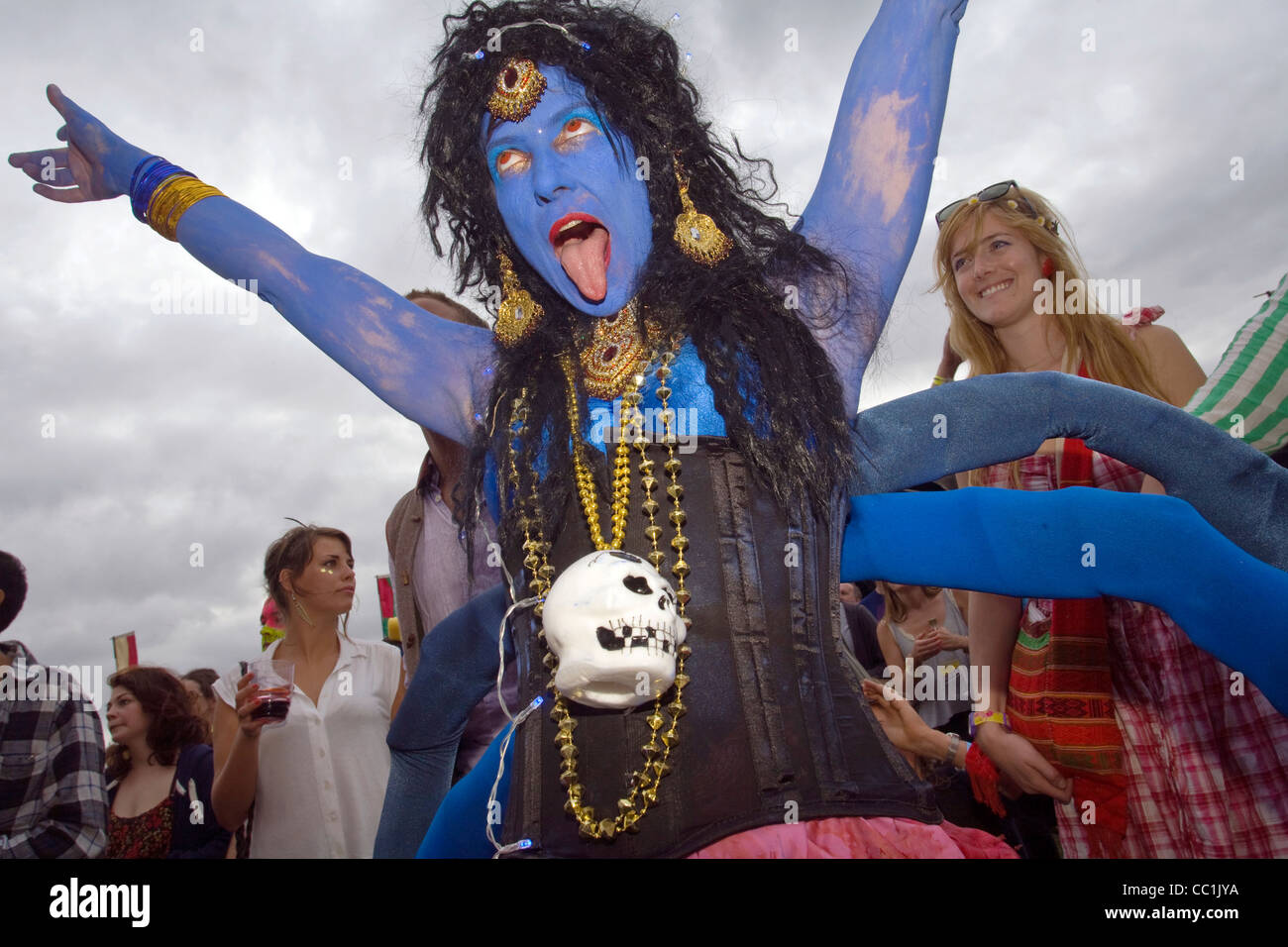 A woman dressed as the Indian Goddess Kali with blue body paint cheers in  the audience at the Standon Calling Festival Stock Photo - Alamy