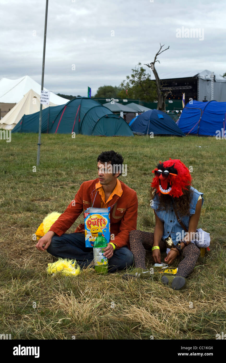 A couple in costume sit in a field at the Standon Calling Festival in Hertfordshire Stock Photo