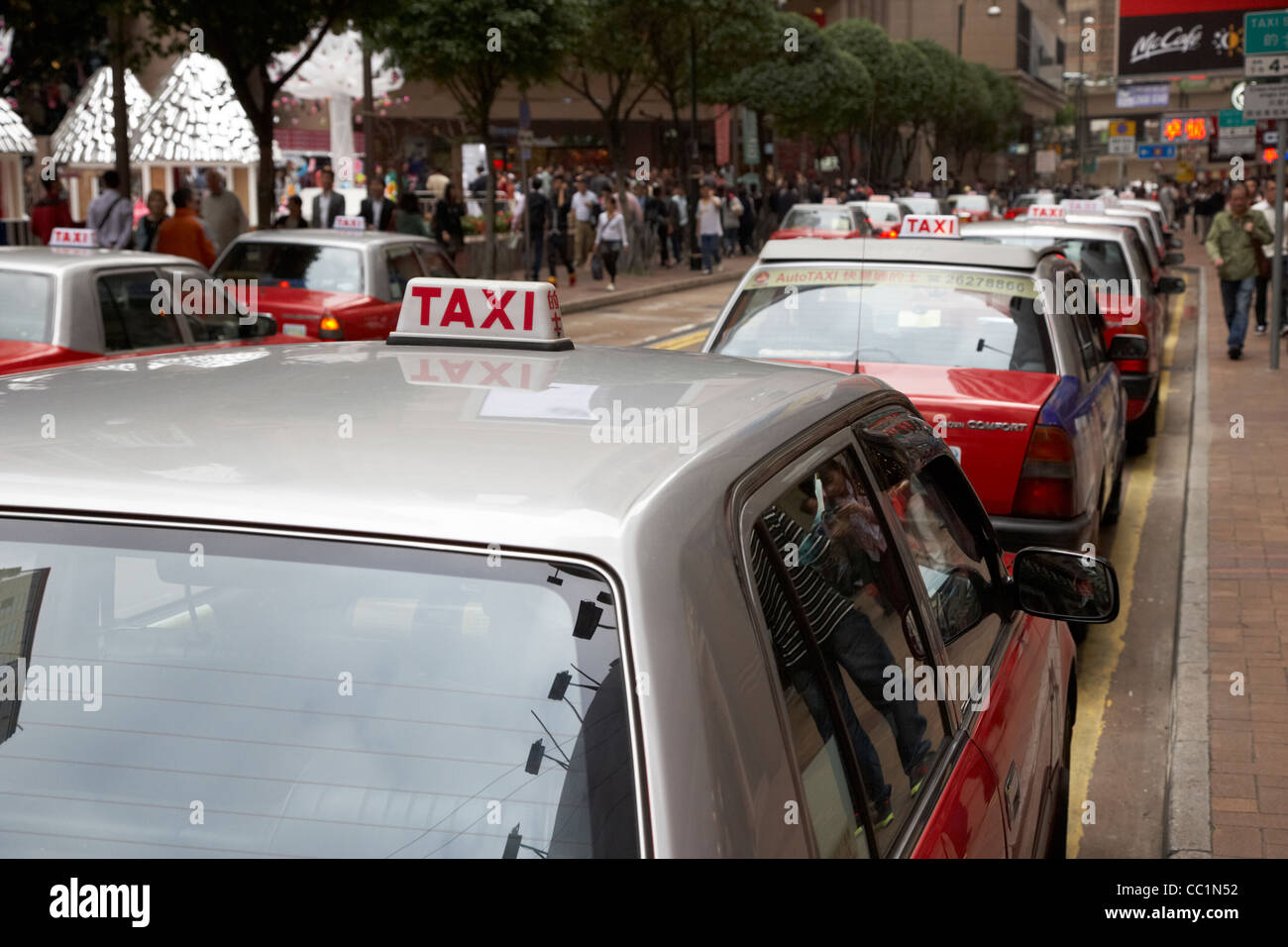 rows of red and silver hong kong taxi cabs in shopping district hksar china asia Stock Photo