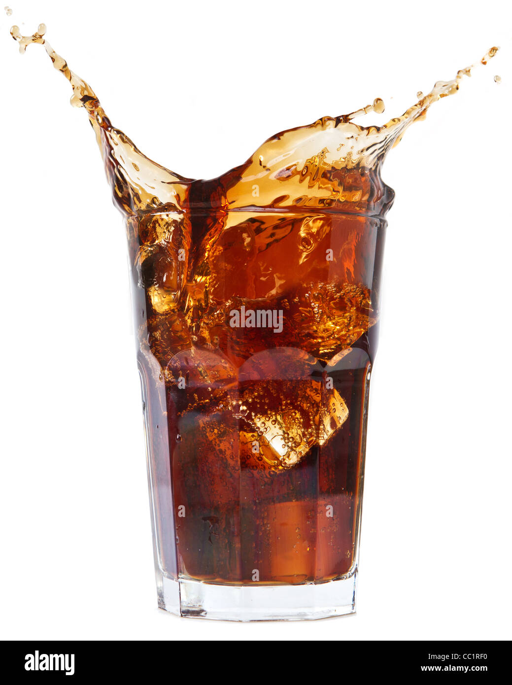 Ice cube droped in cola glass and cola splashing Stock Photo