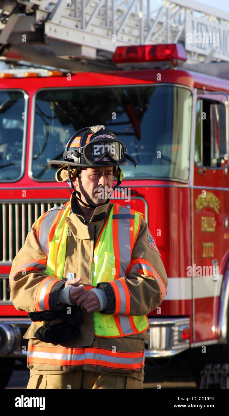 A firefighter in front of a ladder fire truck Stock Photo - Alamy