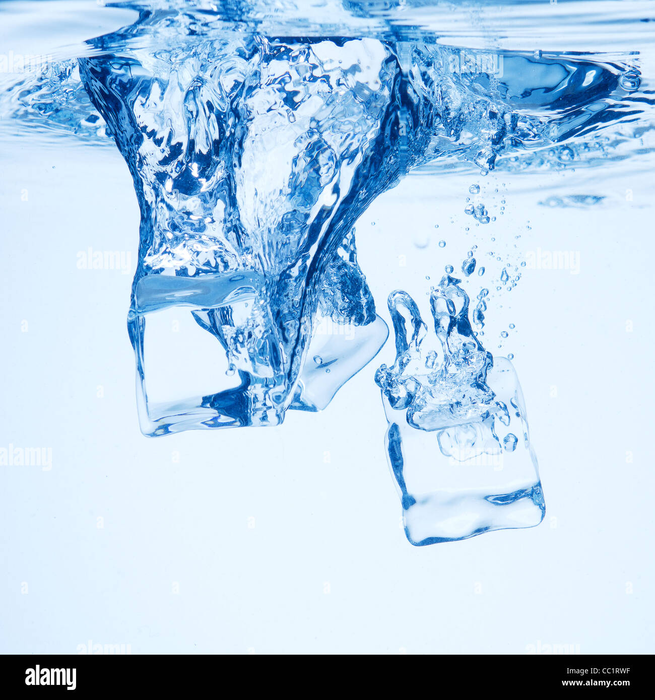 A background of bubbles forming in blue water after ice cubes are ...