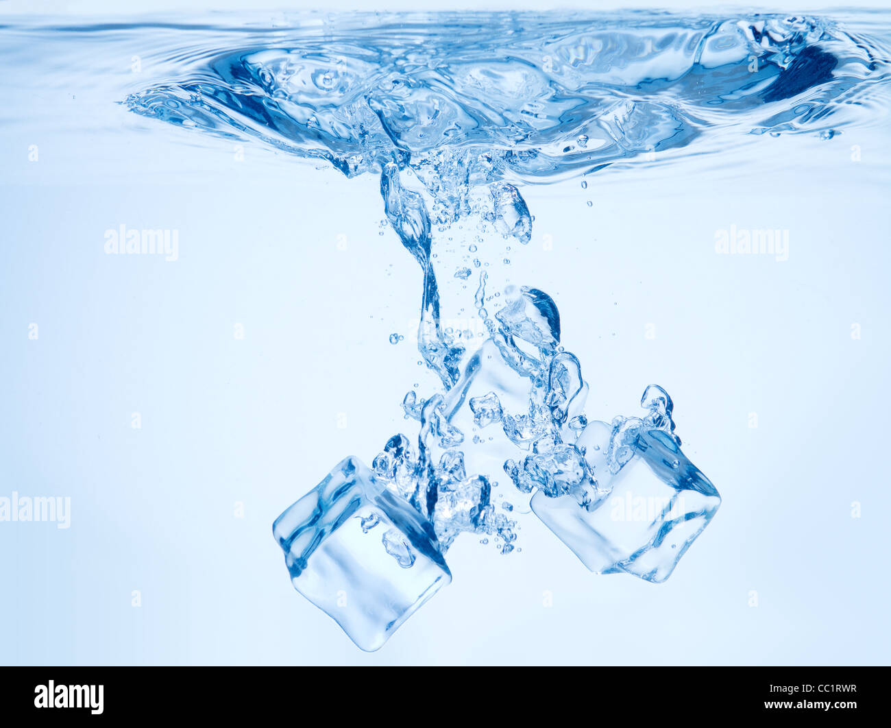 A background of bubbles forming in blue water after ice cubes are ...
