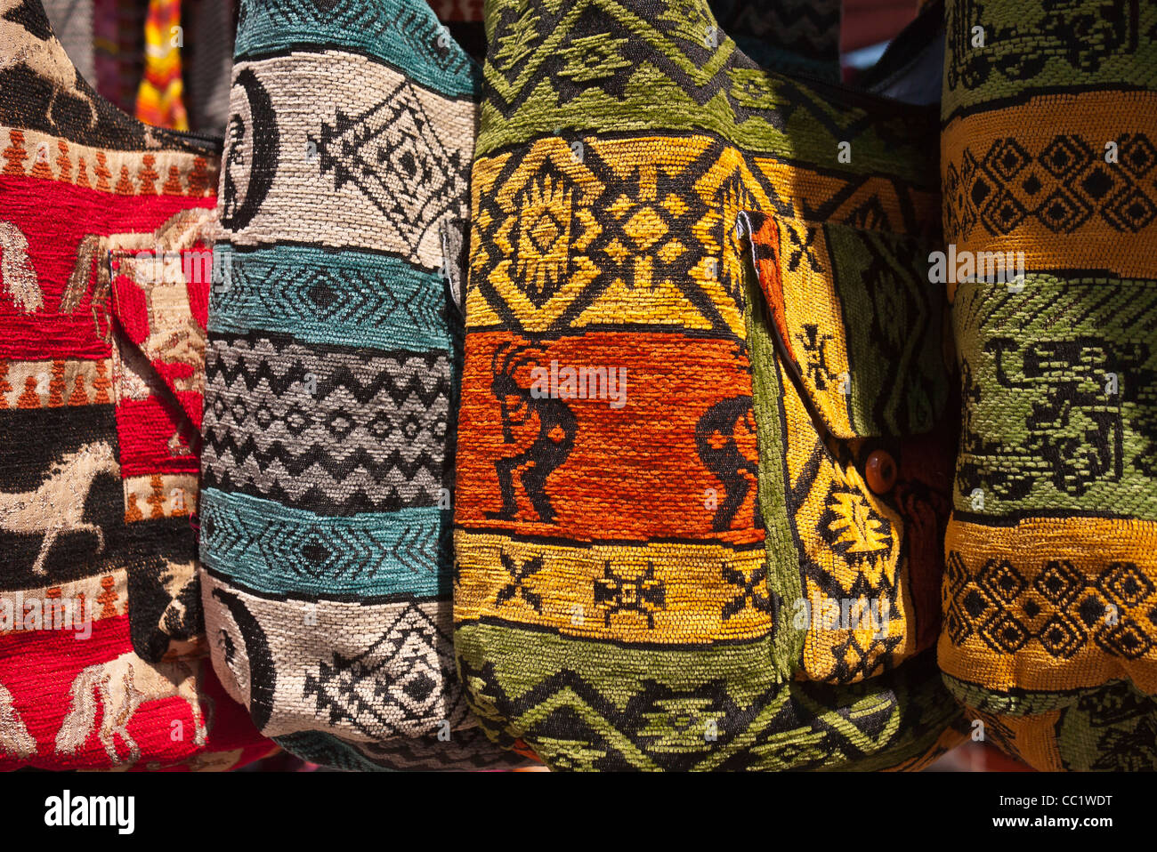 Woven handbags hang for sale in the sunshine of the outdoor market in Otavalo, Ecuador. Stock Photo