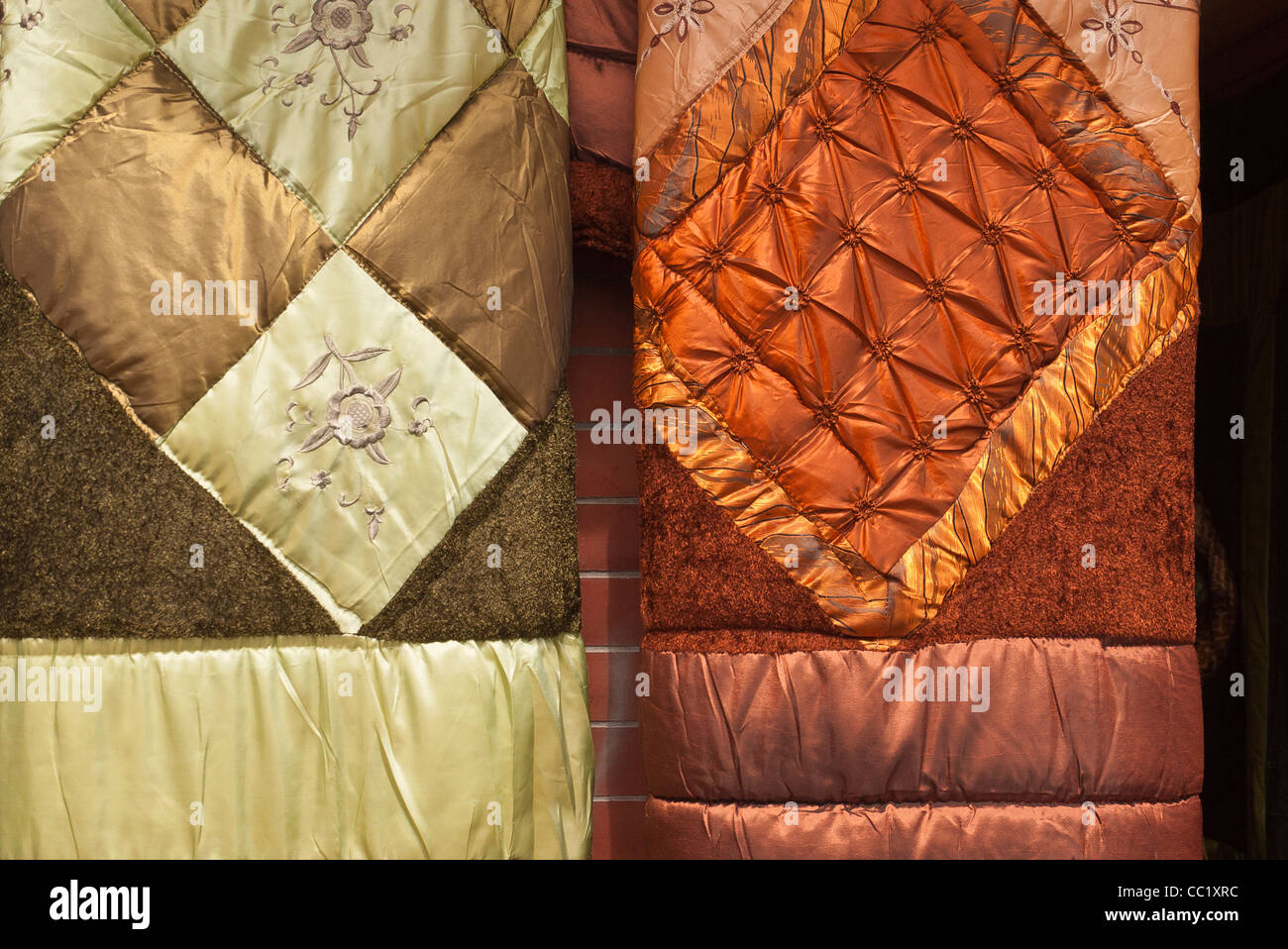 Two colorful satin quilts hang side by side outside a store outside a store in Otavalo, Ecuador. Stock Photo