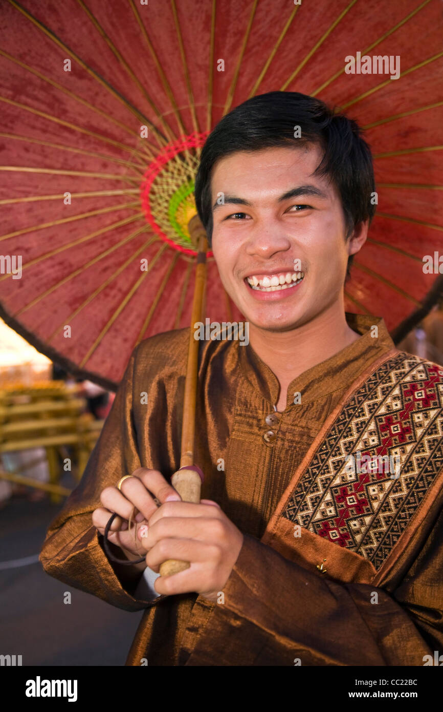 Man in traditional dress with parasol at Yi Peng festival parade. Chiang Mai, Chiang Mai, Thailand Stock Photo