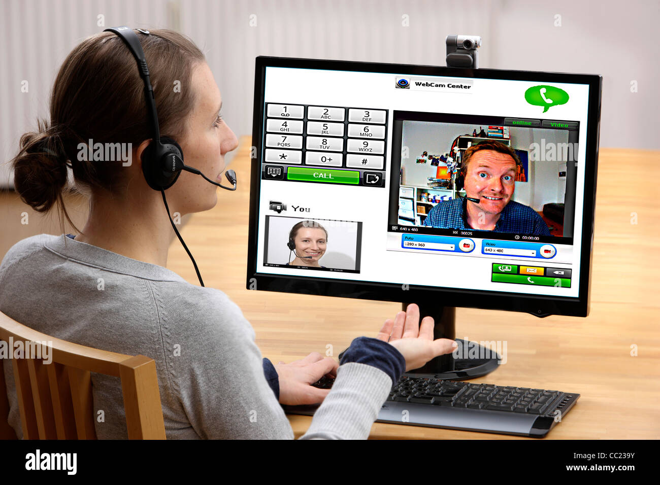 Two people talking over the Internet. Video chat with, with web cam and headset through voice over IP, VOIP. Live online chat. Stock Photo