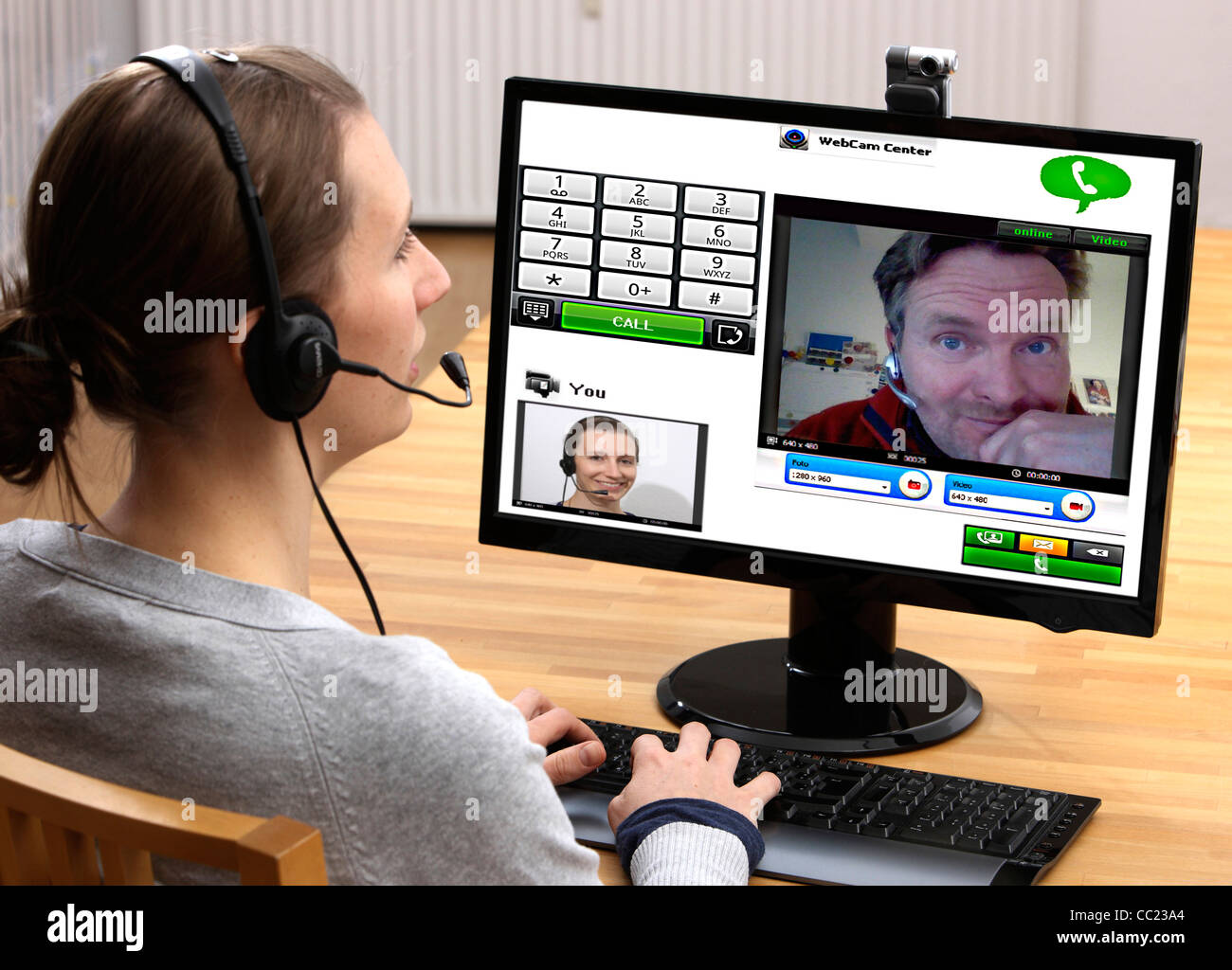 Two people talking over the Internet. Video chat with, with web cam and headset through voice over IP, VOIP. Live online chat. Stock Photo