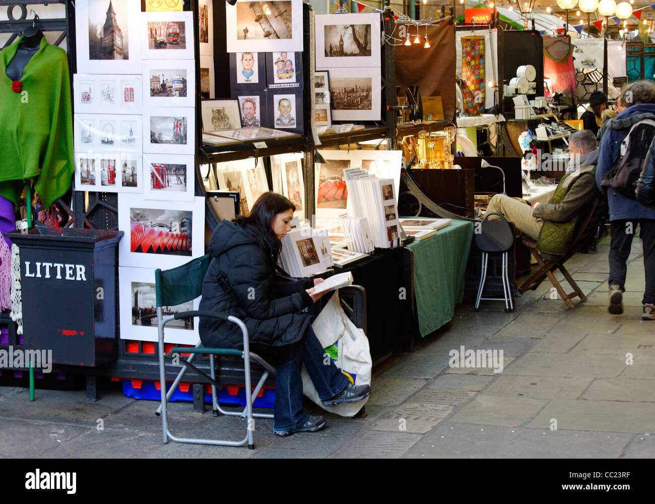 Market traders reading books whilst waiting for business, Covent Garden, London Stock Photo