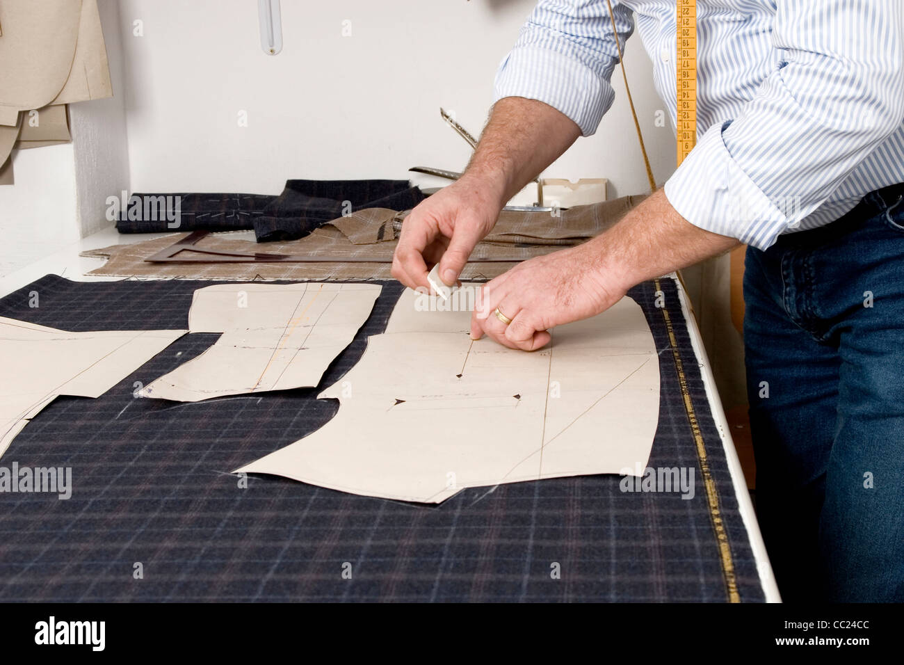 Tailor at work, drawing line on fabric with chalk Stock Photo - Alamy