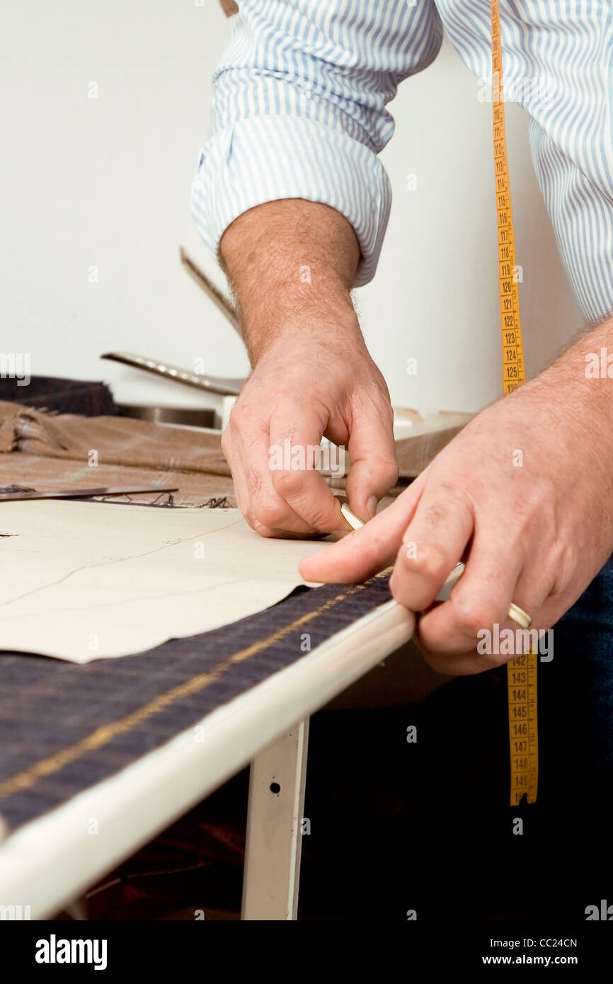 Tailor at work, drawing line on fabric with chalk Stock Photo Alamy