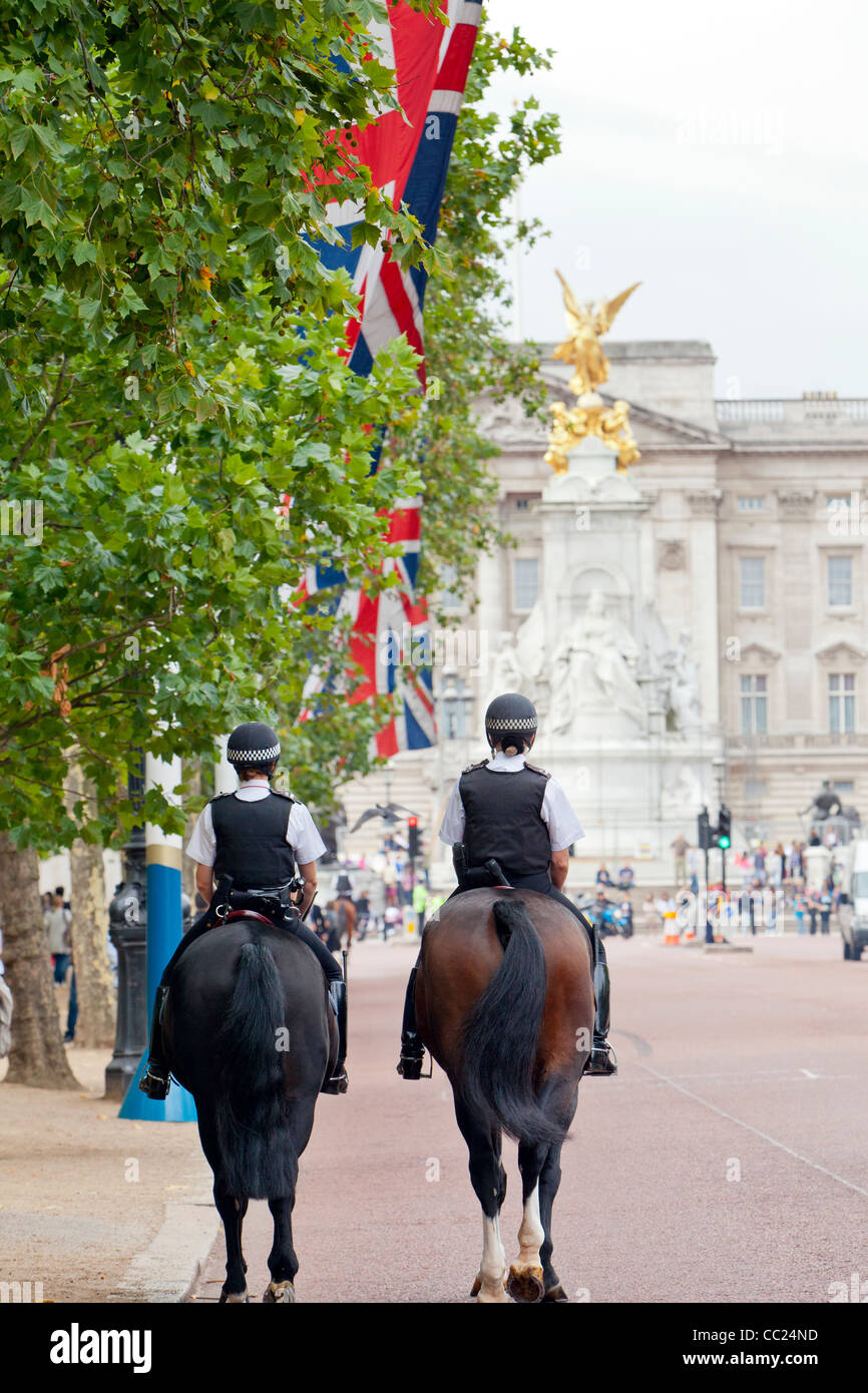 London polce officers riding horses on The Mall and marching towards