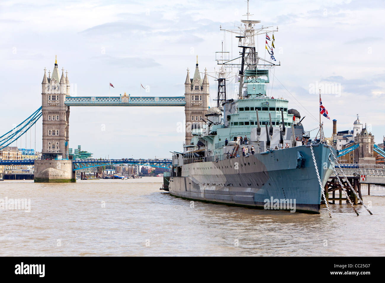 Cruise boats taking tourists on a ride on the Thames River and seeing the Tower Bridge and the HMS Belfast. Stock Photo