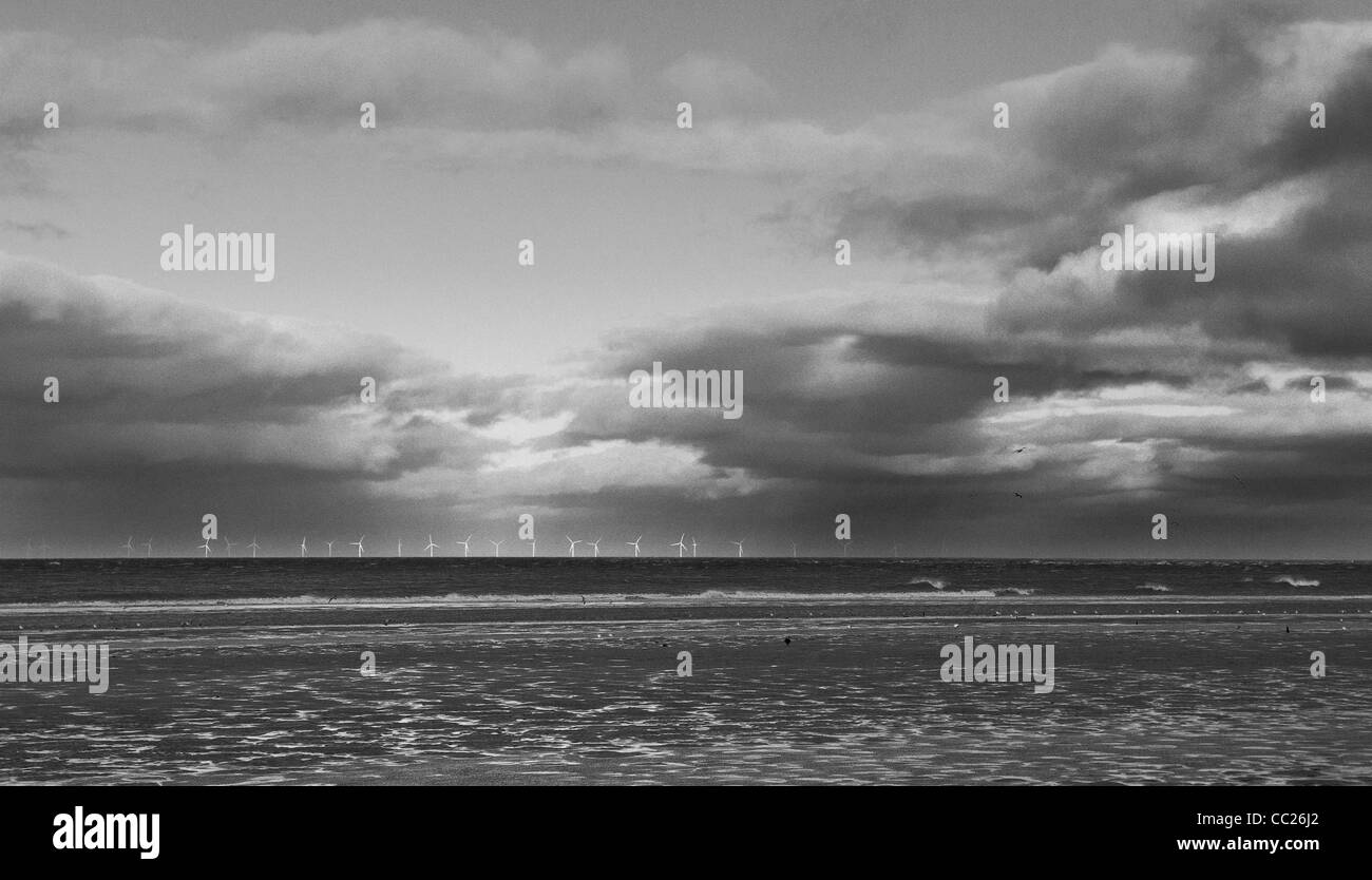 Talacre wind farm on horizon against evening clouds, far distance, black & white Stock Photo