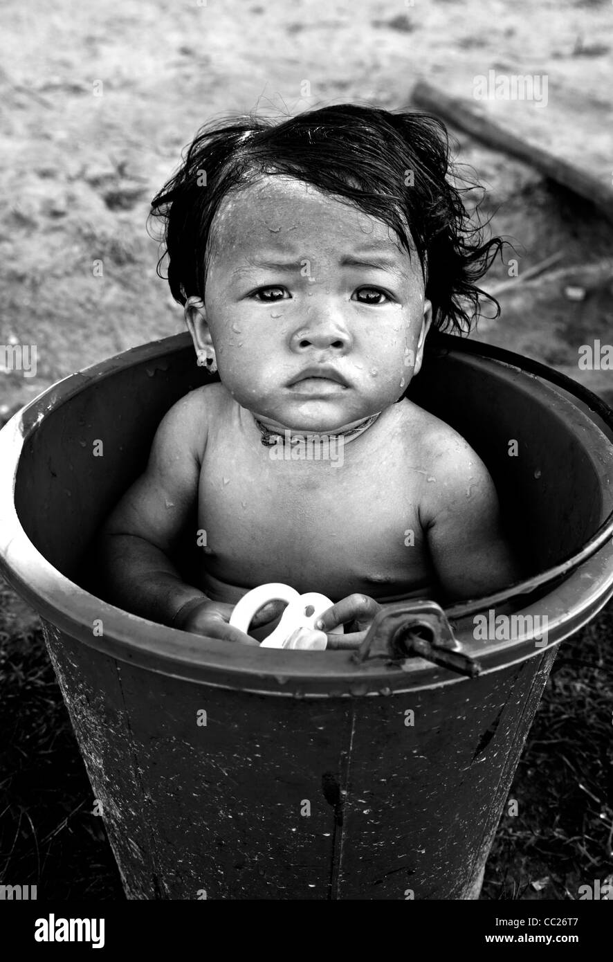 Baby girl bathing in a bucket on the island of Don Det, Laos (colour
