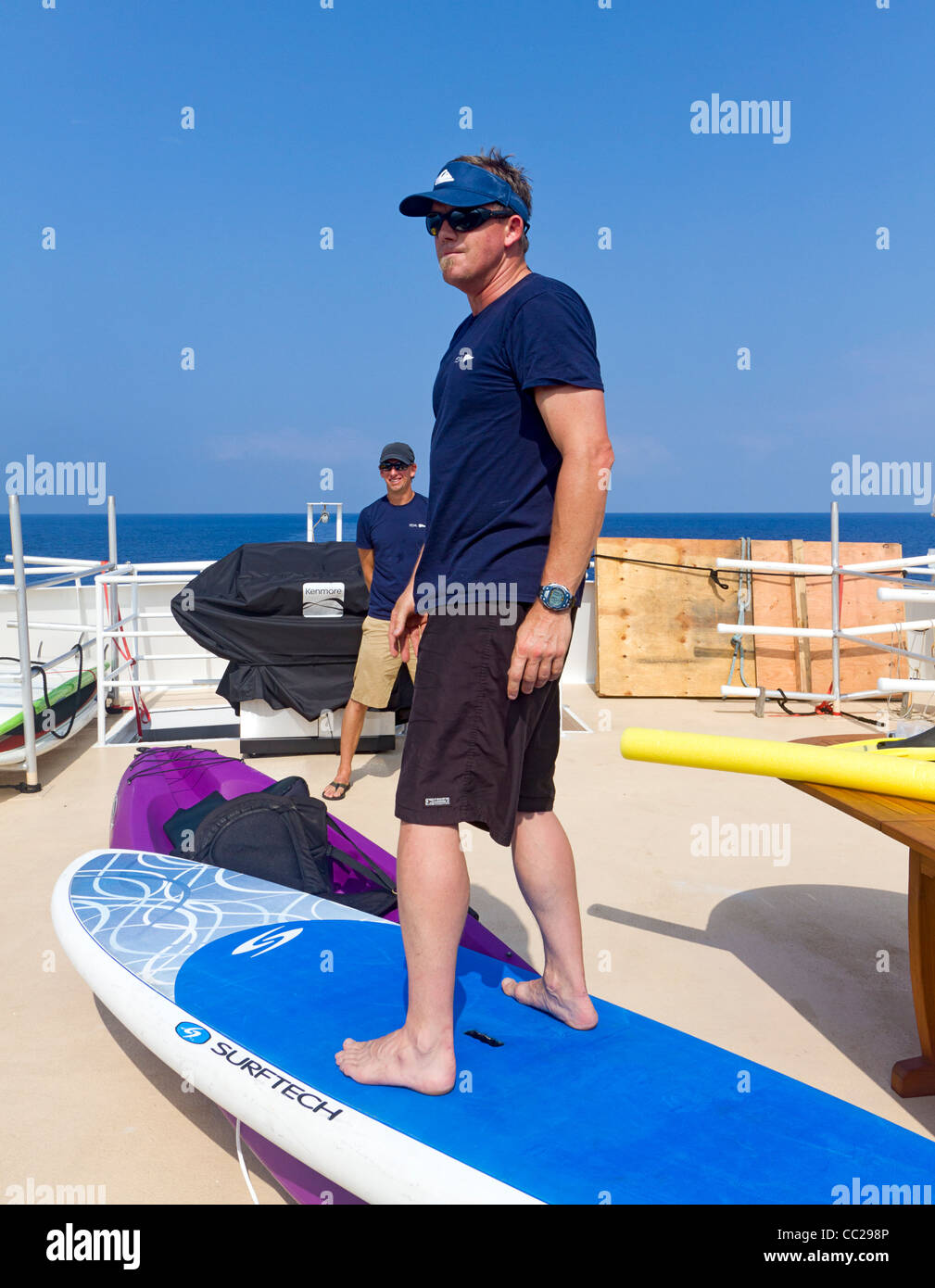 Expedition leaders explain stand up paddle board to cruise passengers aboard American Safari