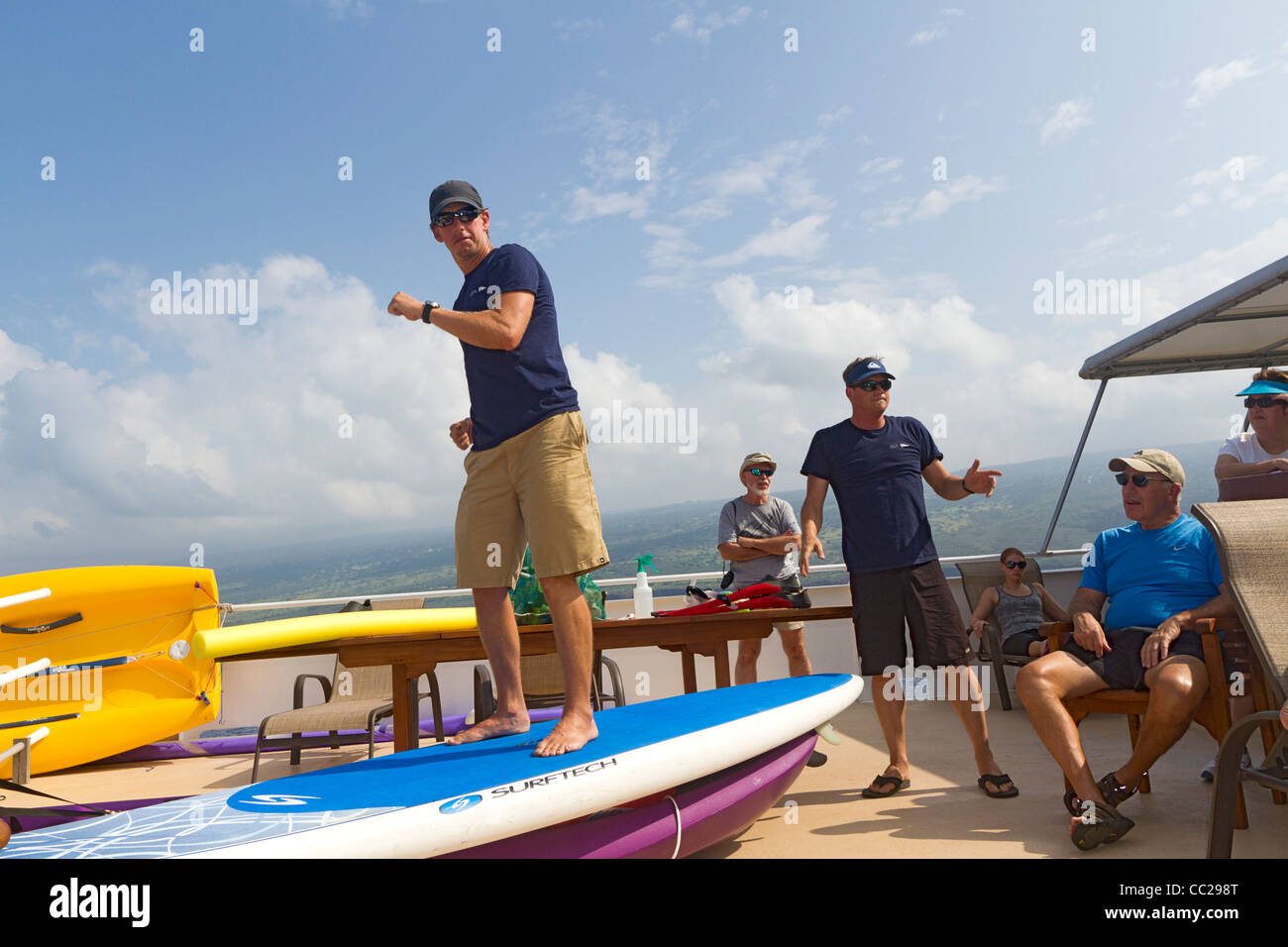 Expedition leaders explain stand up paddle board to cruise passengers aboard American Safari