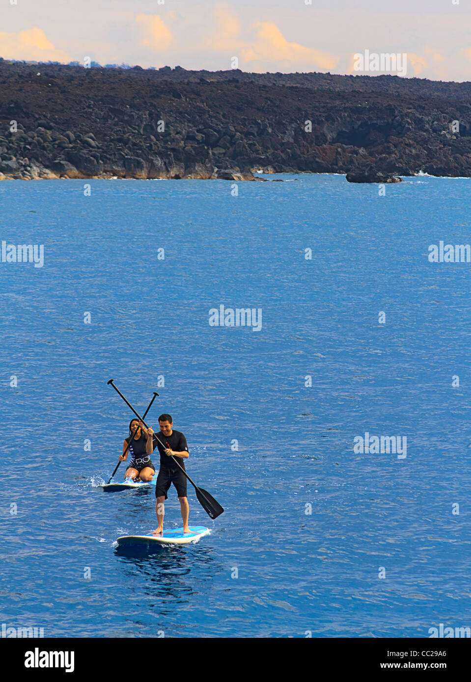 Man and woman on stand up paddleboards in Hawaii. Stock Photo