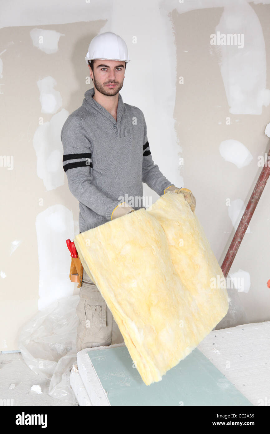 Worker handling square of insulation Stock Photo