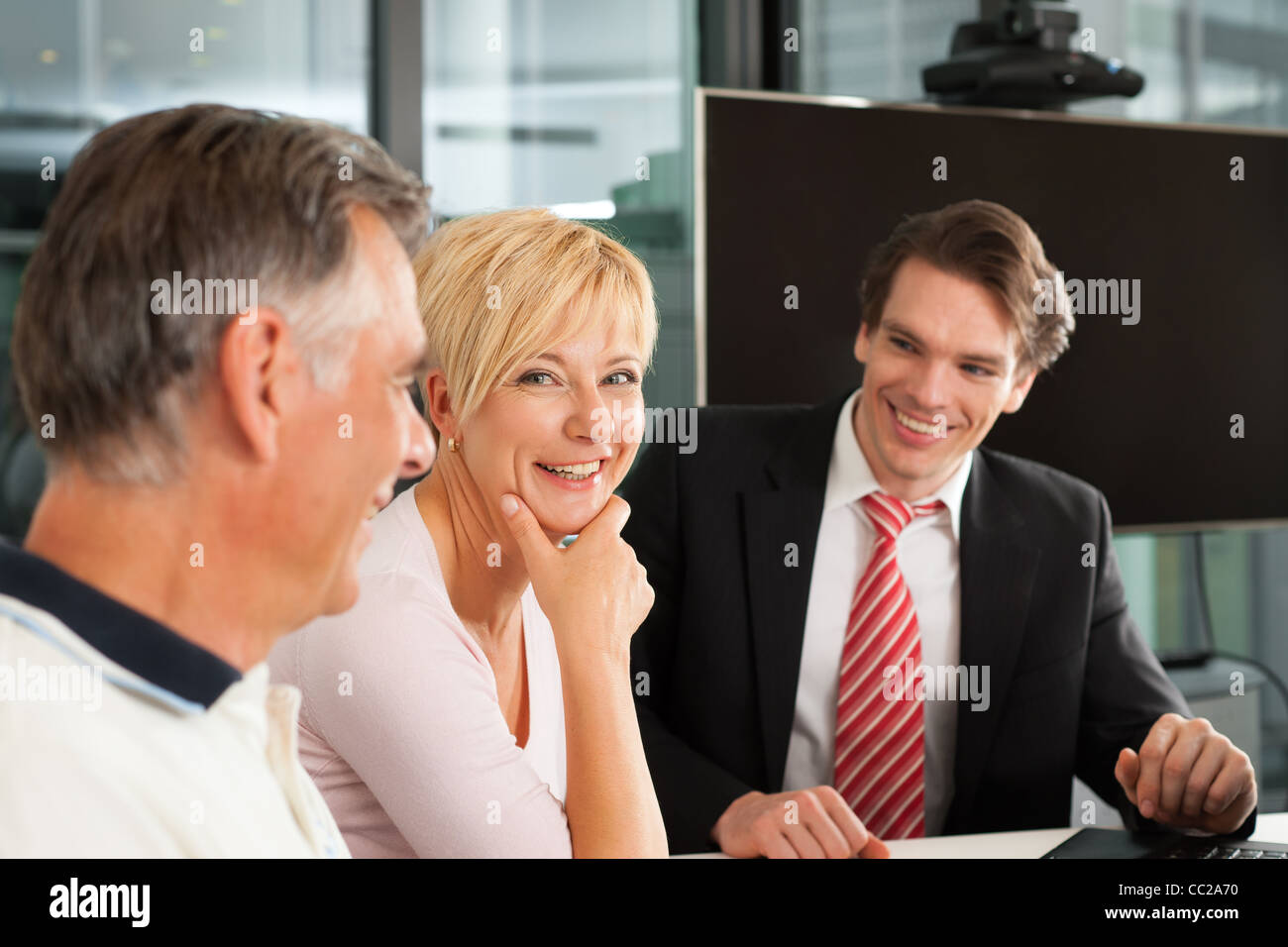Mature couple with young financial consultant - they are planning their retirement Stock Photo