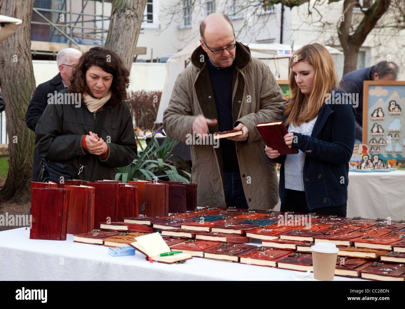 People looking at homemade notebooks at the All Saints Craft Market, Trinity Street Cambridge UK Stock Photo